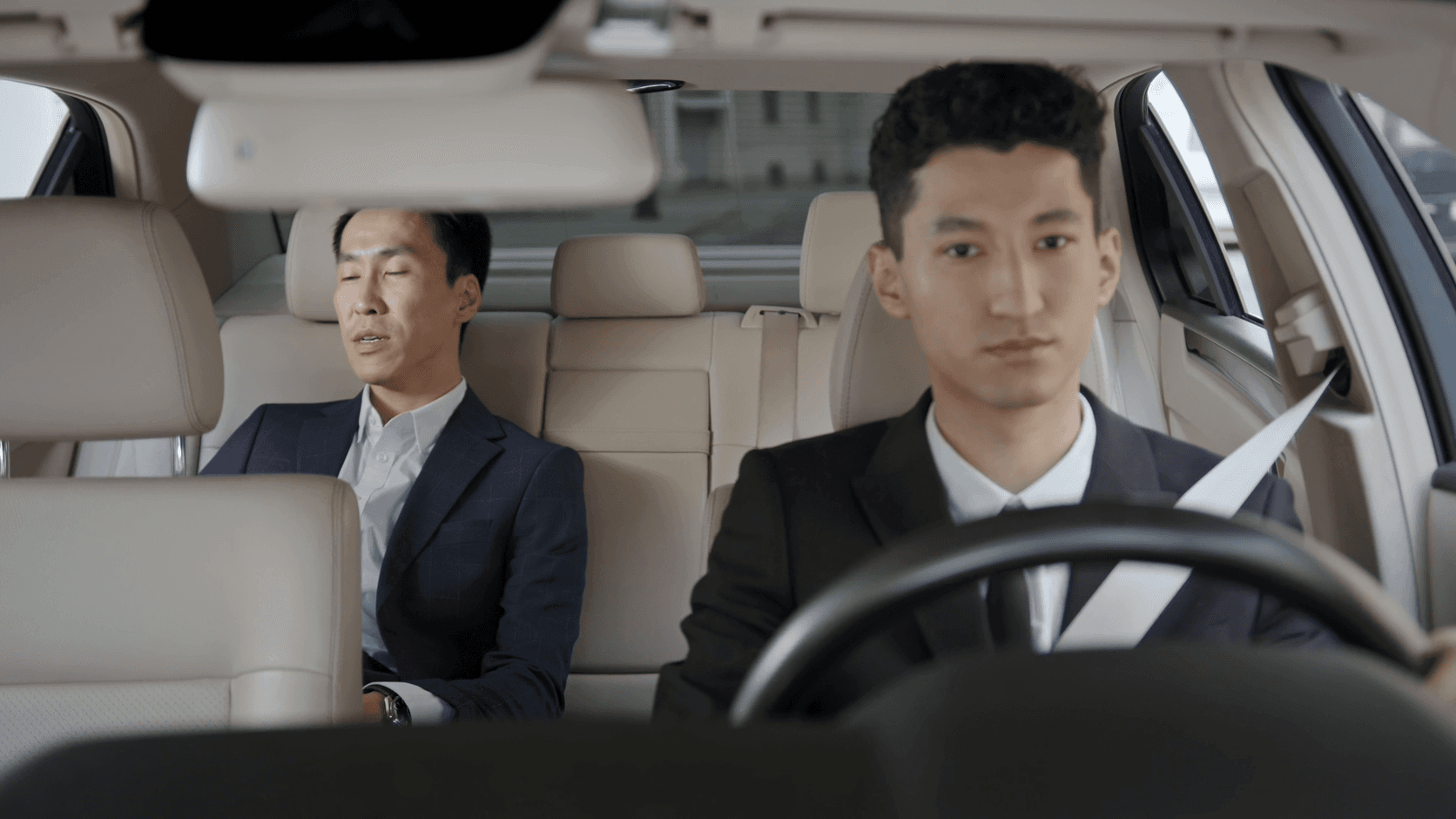 Chauffeur driving a business passenger seated in the back of a sedan