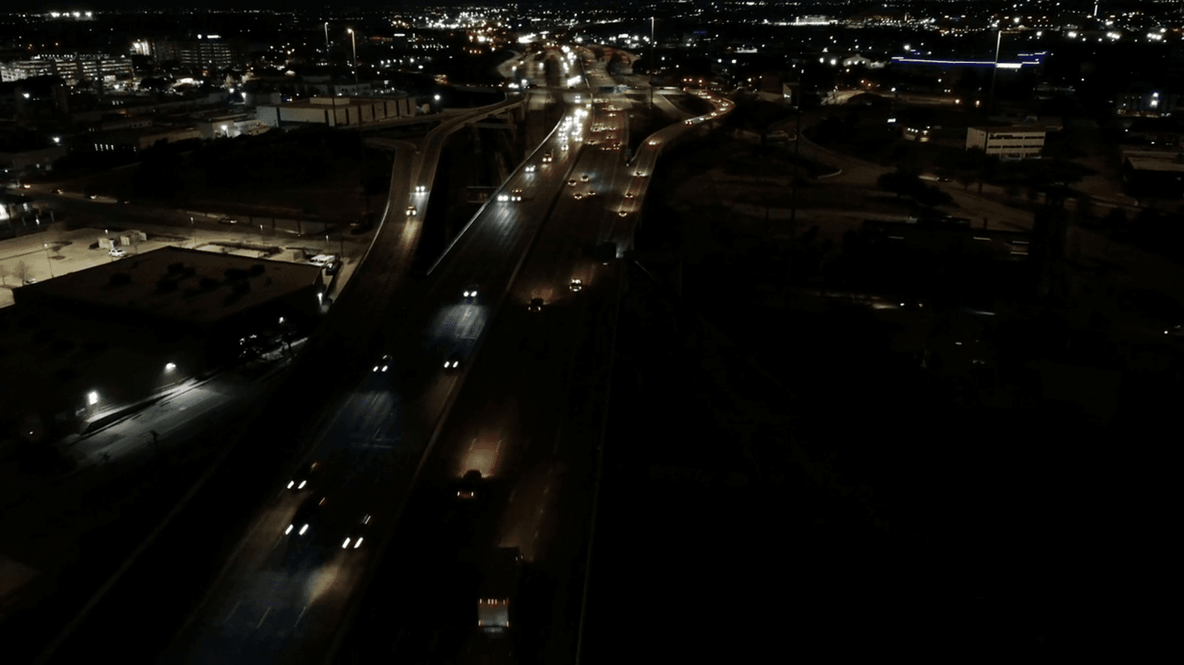 Aerial view of a city highway at night with car lights